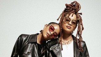 Photo of DJs Coco and Breezy posing in leather while wearing sunglasses