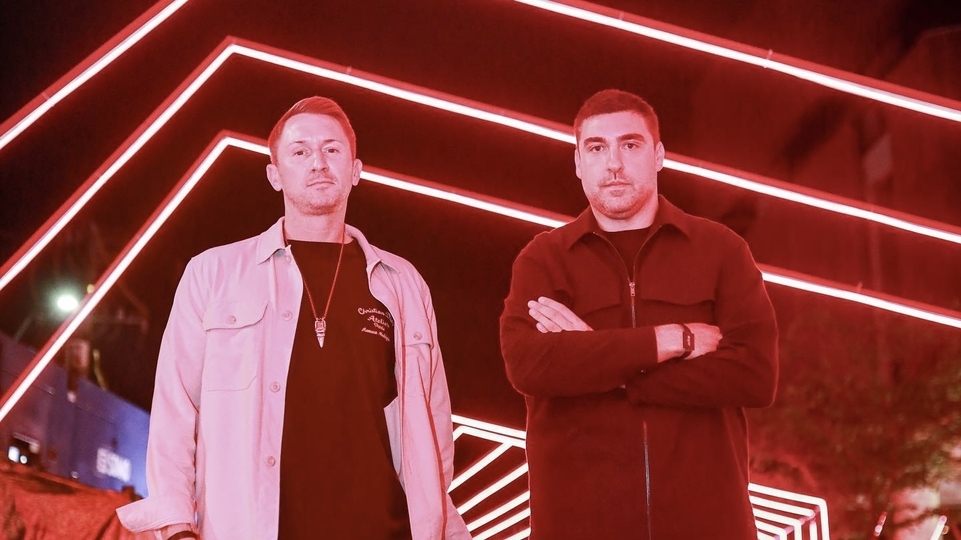 Photo of CamelPhat posing in front of red ceilings lights in Medellín, Colombia