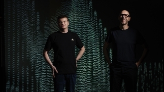 Photo of Tom Rowlands and Ed Simons from the chemical brothers with a green and black background