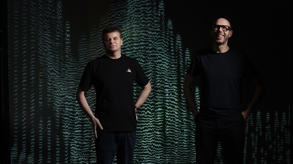 Photo of Tom Rowlands and Ed Simons from the chemical brothers with a green and black background