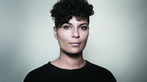Virgina poses in a portrait image wearing a black top